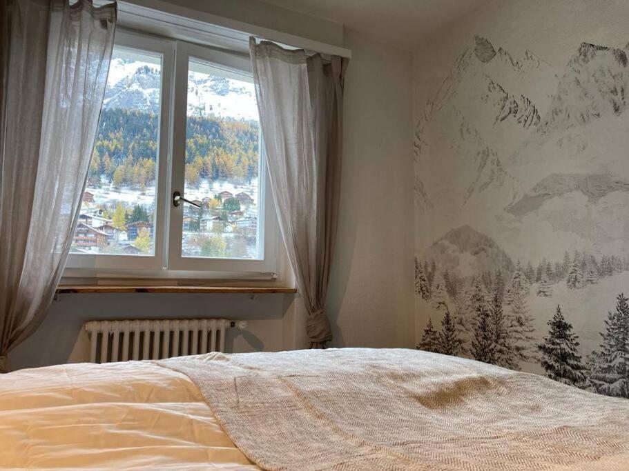 een slaapkamer met een bed en een raam met uitzicht bij Best views and location in Leukerbad! in Leukerbad