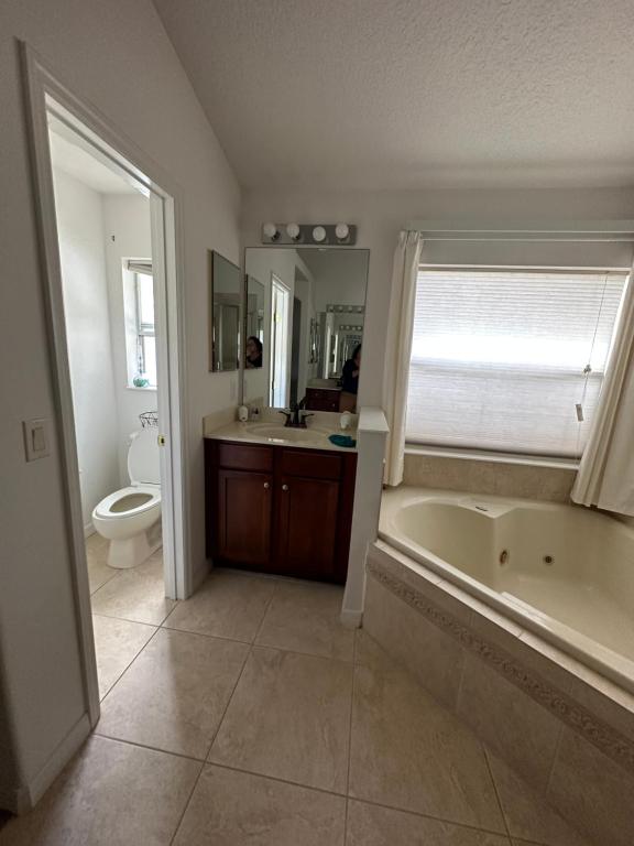 een badkamer met een bad, een wastafel en een toilet bij Susan’s Place in Deltona