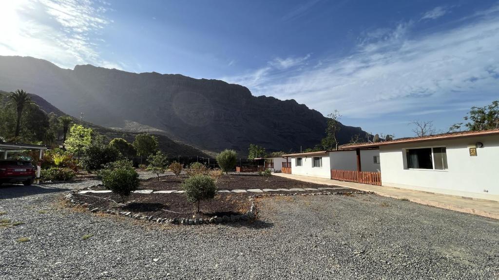 a parking lot in front of a house with a mountain at Modern Tiny Country House near Fataga & Maspalomas in Artedara
