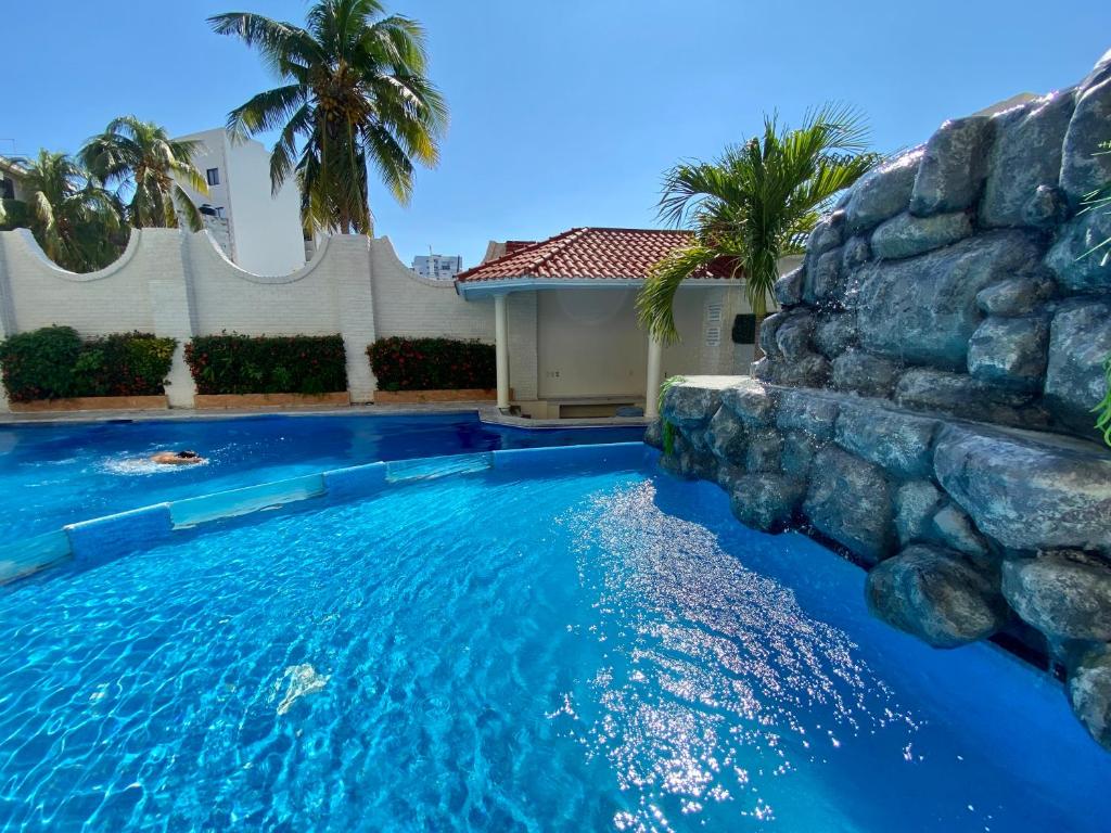 a swimming pool with a rock wall at Hotel Playa de Oro - Enfrente de WTC y Plazas Comerciales in Veracruz