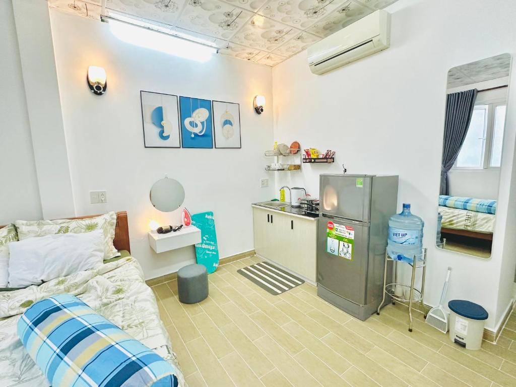 een slaapkamer met een bed en een keuken. bij Cozy & Quiet 1BR Oasis in the heart of Ho Chi Minh City in Ho Chi Minh-stad