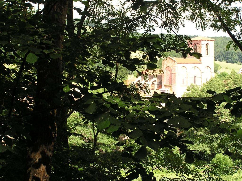 an old house in the middle of a field with trees at Chez Bernard et Michèle in Manglieu