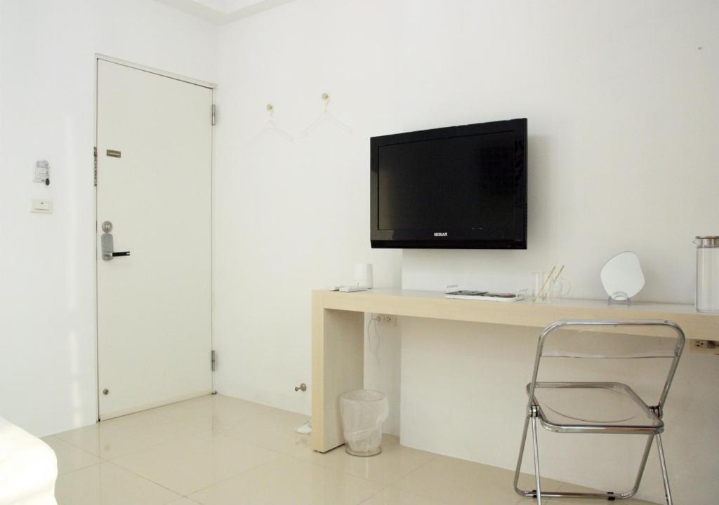 a room with a desk with a tv and a chair at 夕映安平 in Tainan