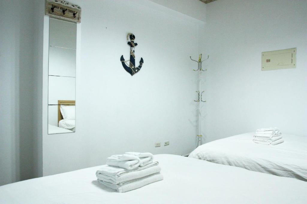 a white room with two beds and towels at 夕映安平 in Tainan