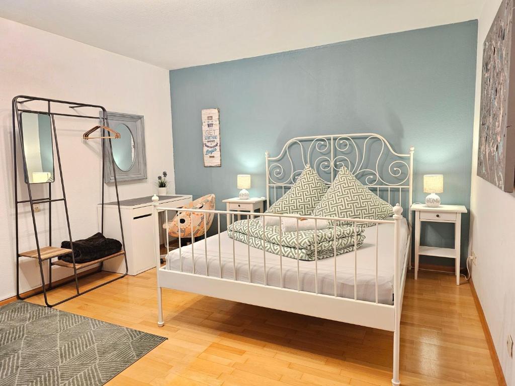 una camera con un letto bianco e una parete blu di Doppelzimmer 2 I geteiltes Bad & Küche I mit dem Zug nur 4 min bis zum Hauptbahnhof a Friburgo in Brisgovia
