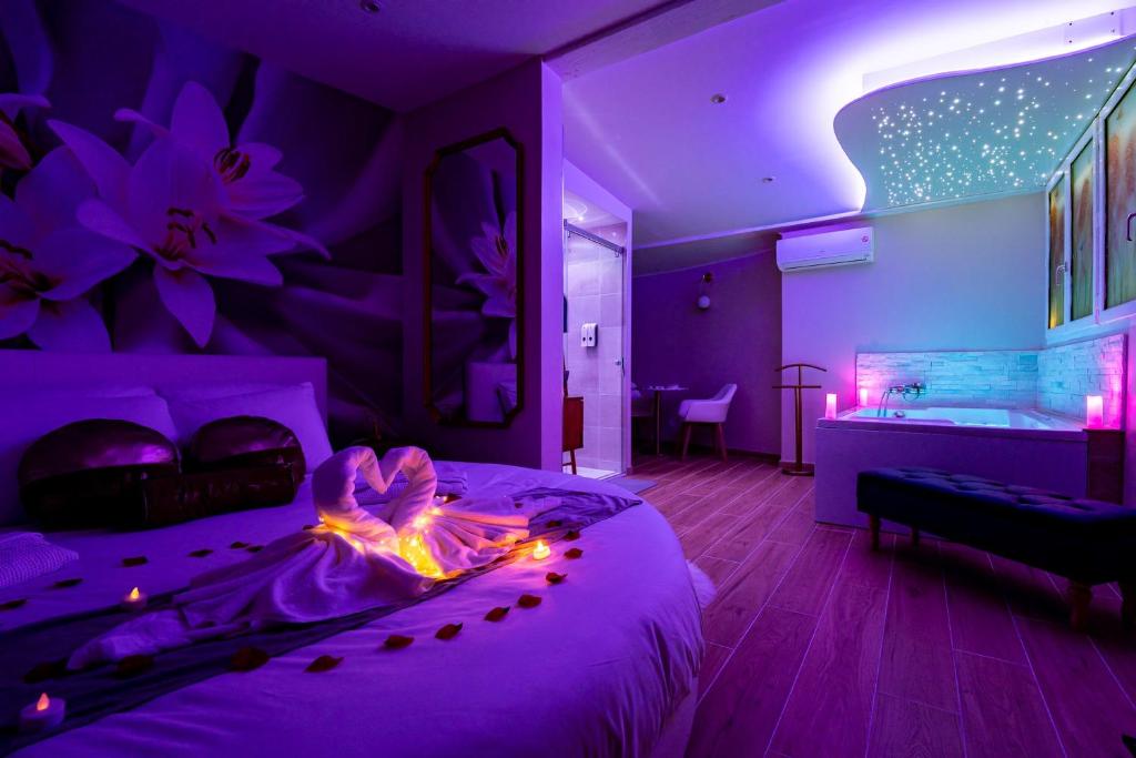 una camera viola con letto e vasca di Studio romantique jacuzzi ou spa balneo privatif et jardin Au temps des cerises La Ciotat a La Ciotat