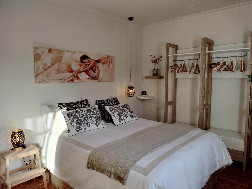 una camera da letto con un grande letto bianco con cuscini di Casa Luz a Costa Calma