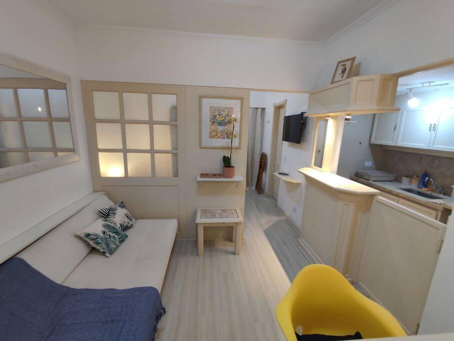 Apartamento pequeño con sofá y silla amarilla en Studio 1403 com vaga de garagem., en São Paulo