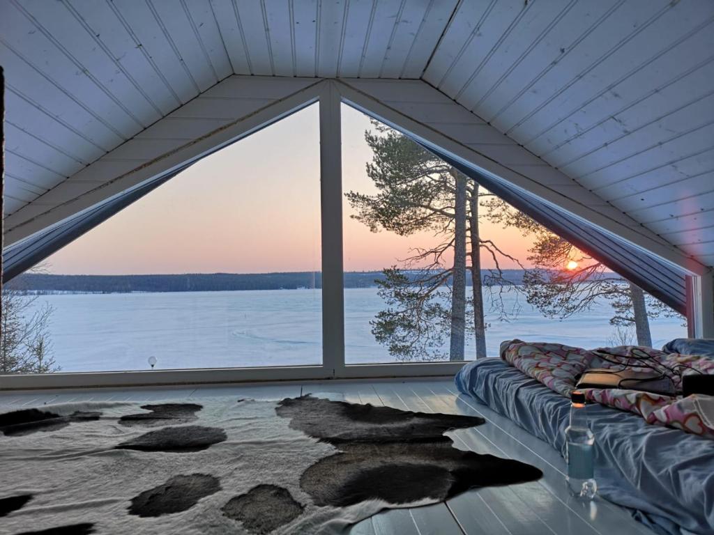 a room with a large window with a view of the water at VillaNorva in Saarenkylä