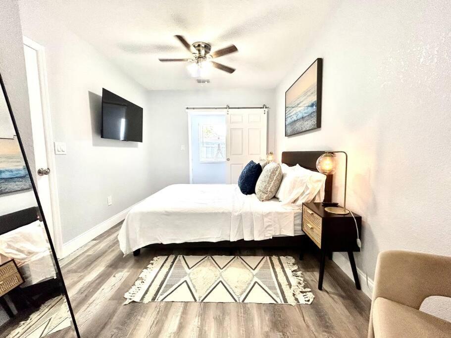 um quarto branco com uma cama e uma ventoinha de tecto em Gorgeous & Convenient Apartment Near Airport em West Palm Beach