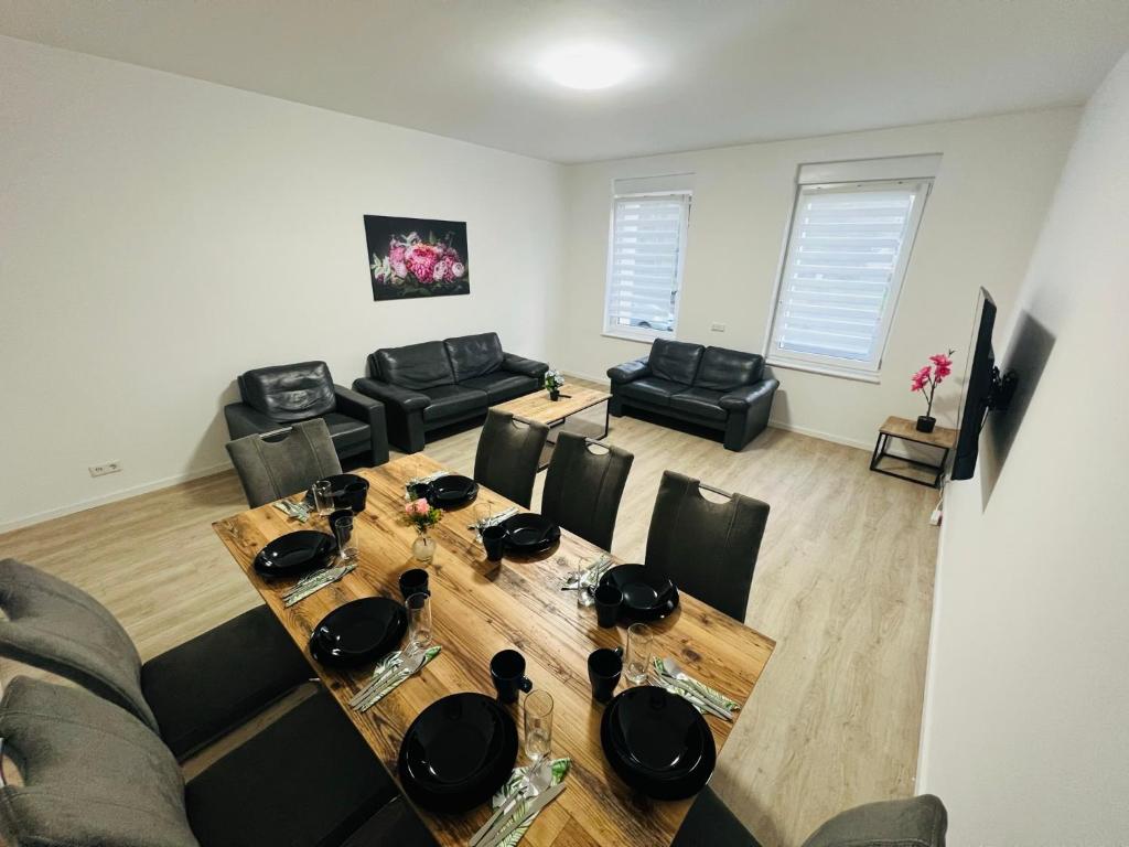 - un salon avec une table et des chaises en bois dans l'établissement City Apartment - 9 Bedrooms - 22 Beds - WiFi - Kitchen, à Paderborn