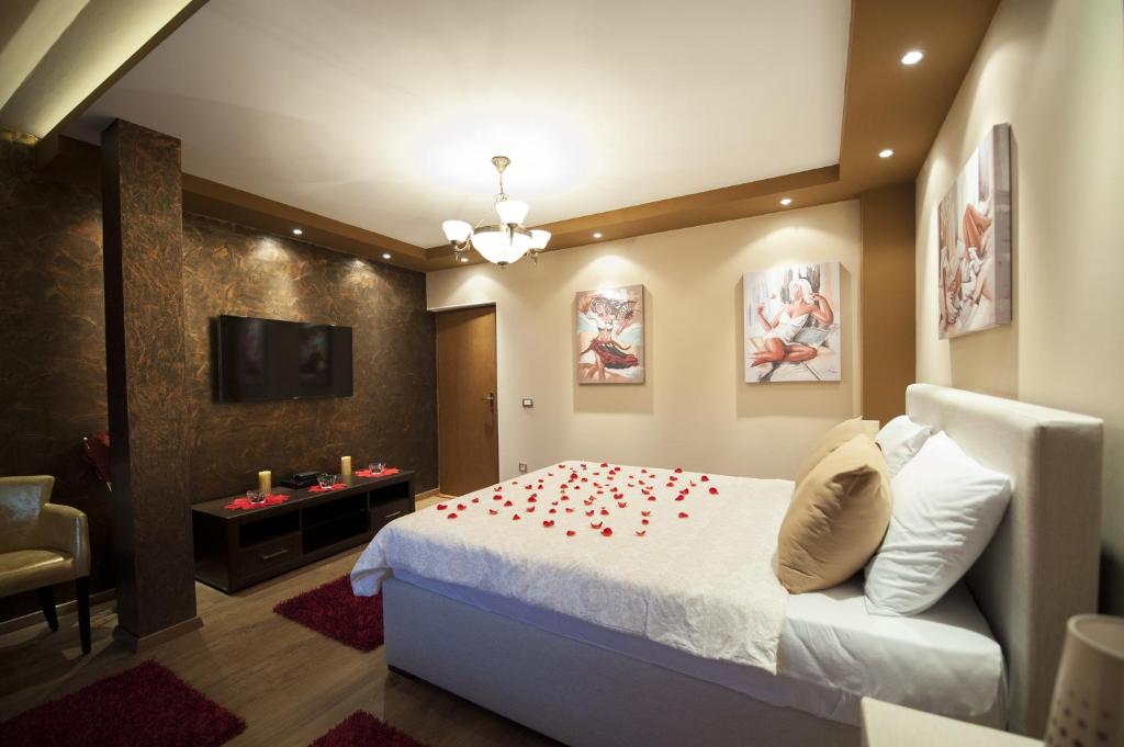 ein Schlafzimmer mit einem Bett mit roten Rosenblättern drauf in der Unterkunft Benvenuti Apartments in Cetinje