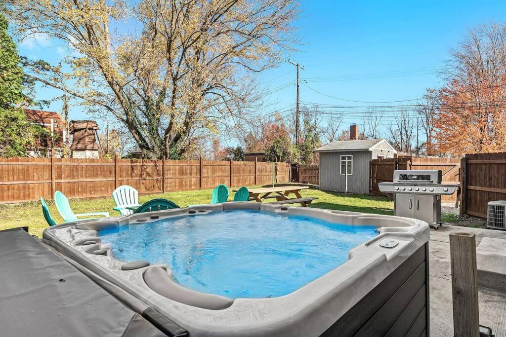 una piccola piscina in un cortile con sedie e una griglia di New! Warm & Cozy 3BR w/ Hot Tub, Firepit & BBQ! a Mount Clemens