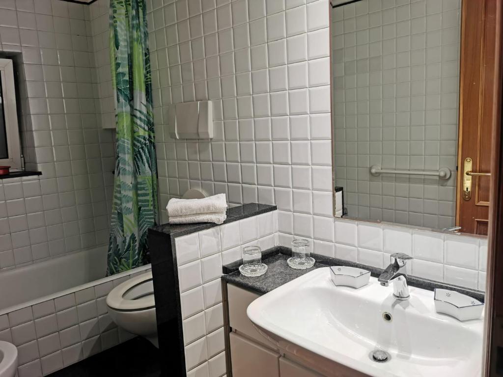bagno con lavandino, servizi igienici e specchio di La Casetta a Roma