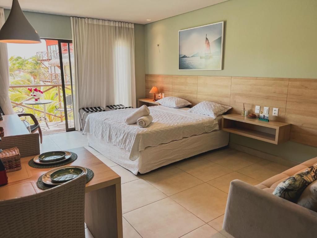 a bedroom with a bed and a table and a couch at Apartamento em Barra Grande, Piauí in Cajueiro
