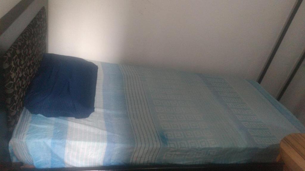 a bed with a blue comforter in a bedroom at Casa San Alonso in Bucaramanga
