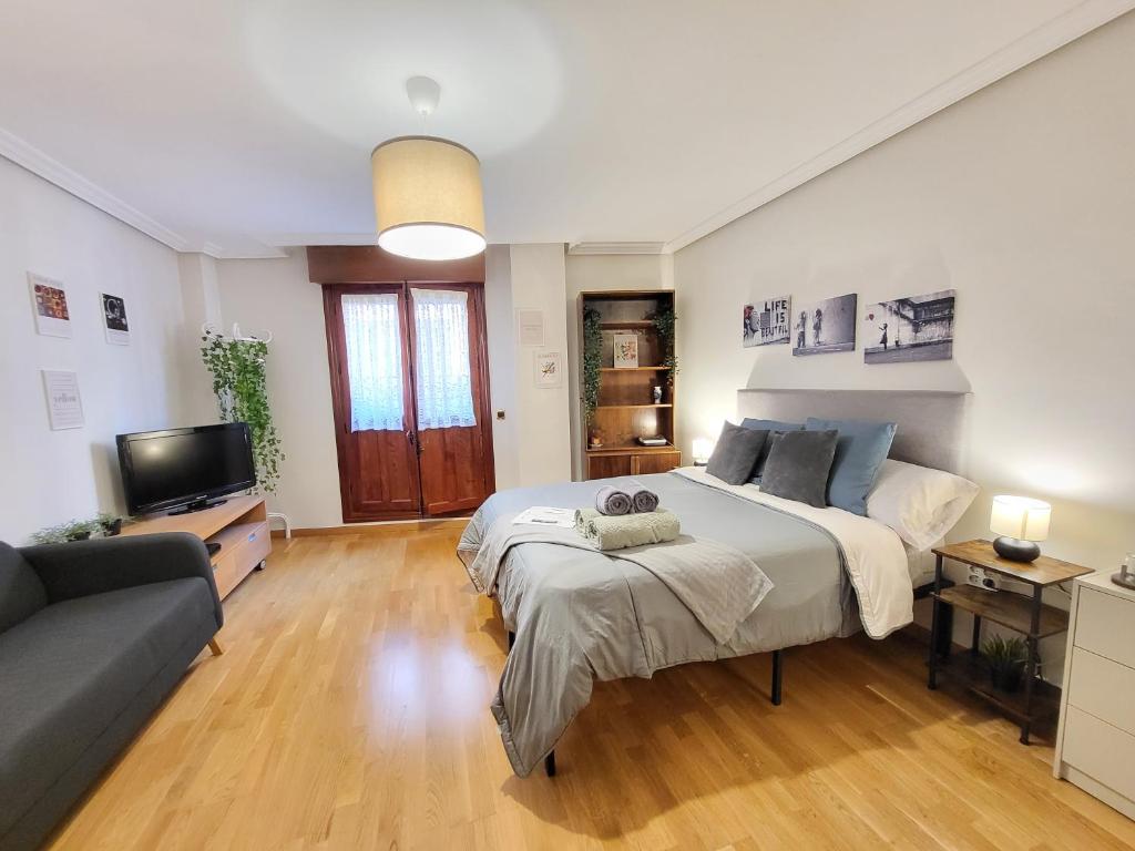 een grote slaapkamer met een groot bed en een bank bij Apartamento Plaza España Gran vía centro in Madrid