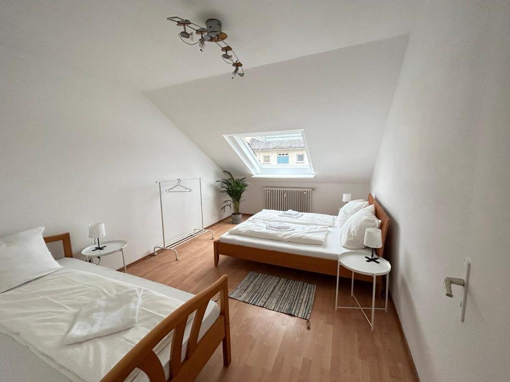 una camera mansardata con due letti e una finestra di GardenApartment a Francoforte sul Meno