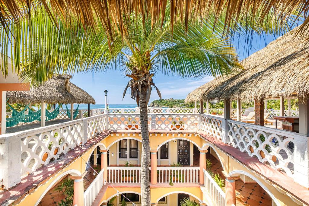 una palmera en el balcón de una casa en Hotel Flor de Maria, en Puerto Escondido