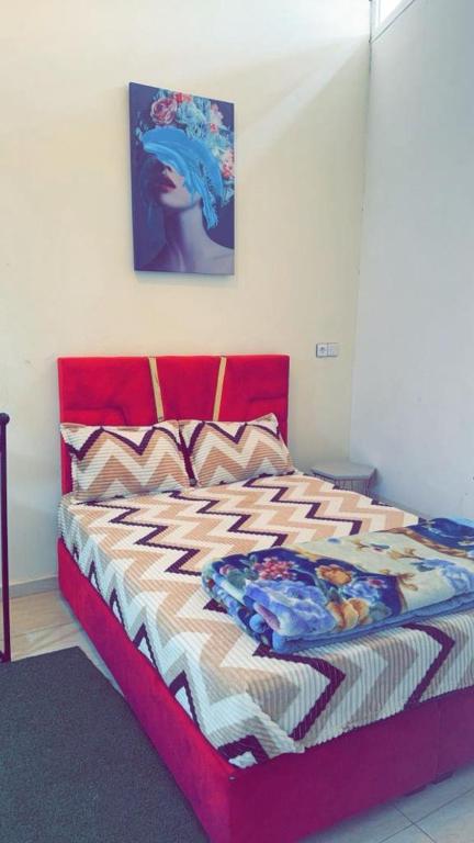 Schlafzimmer mit einem Bett mit rotem Kopfteil in der Unterkunft planet house in Deroua