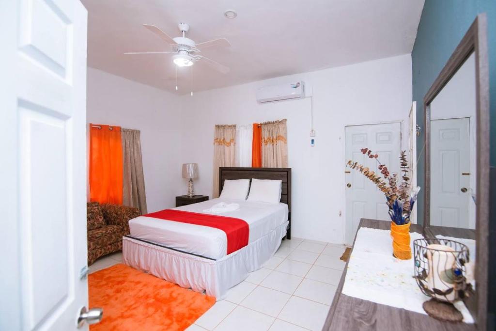 een slaapkamer met een bed met een rode en witte sprei bij Suzette Guesthouse Accommodations in St Mary