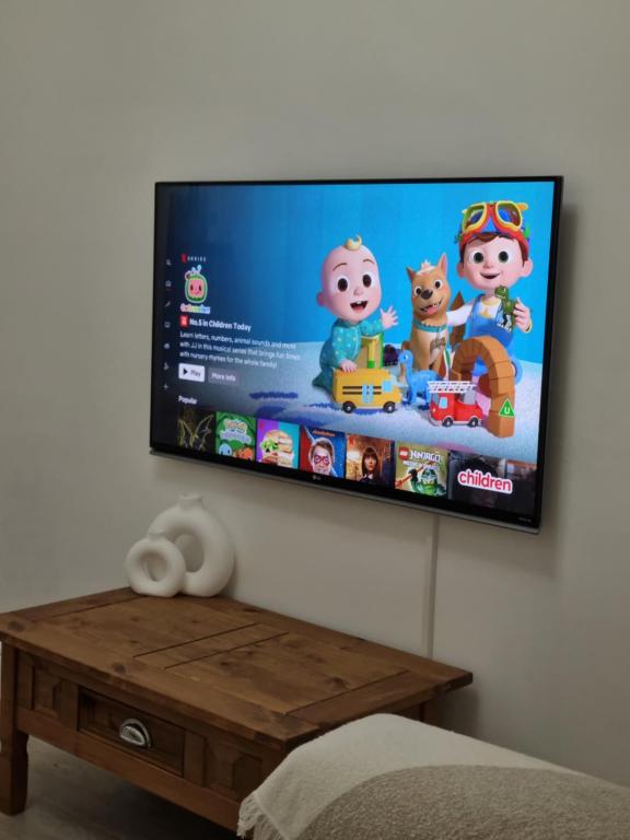 a flat screen tv hanging on a wall at Cosy modern house in Liverpool