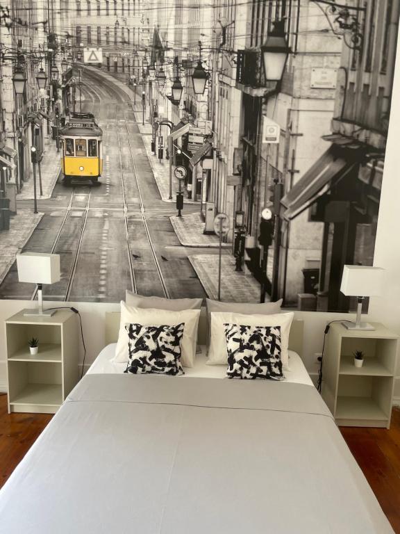 1 dormitorio con cama y tranvía amarillo en Quarto com varanda em Arroios 1, en Lisboa