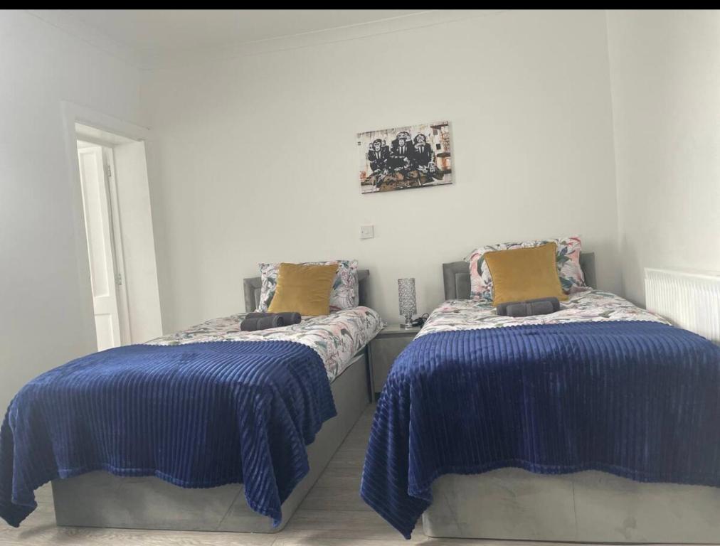 a bedroom with two beds with blue comforters at Samarlon Home Saxton in Gillingham