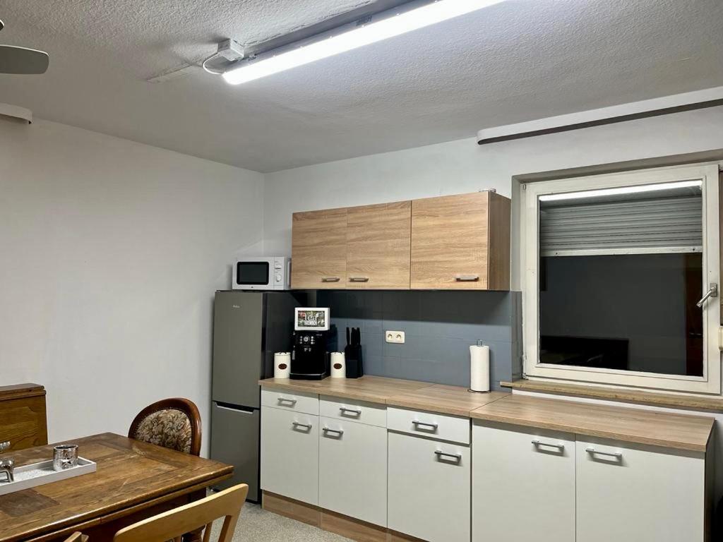 a kitchen with white cabinets and a black refrigerator at Monteurhaus bei EnergyFreund in Hallstadt