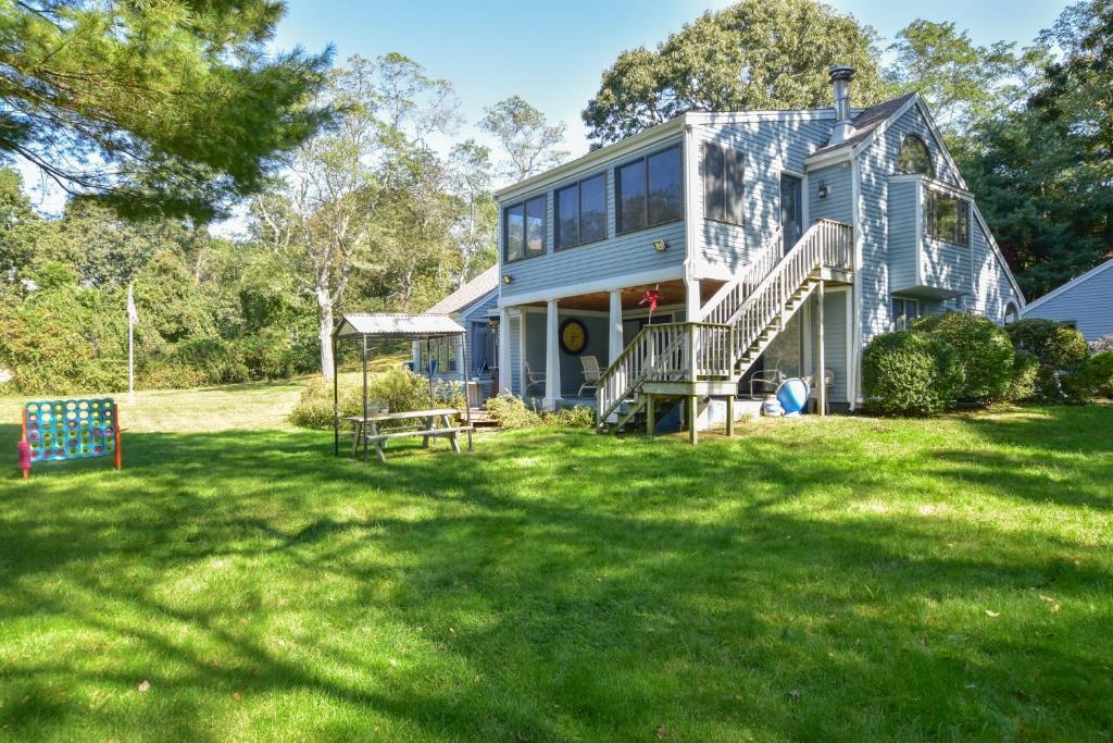 una casa en un patio de césped con árboles en el fondo en Lake House in Centerville with Private Water Access, en Barnstable