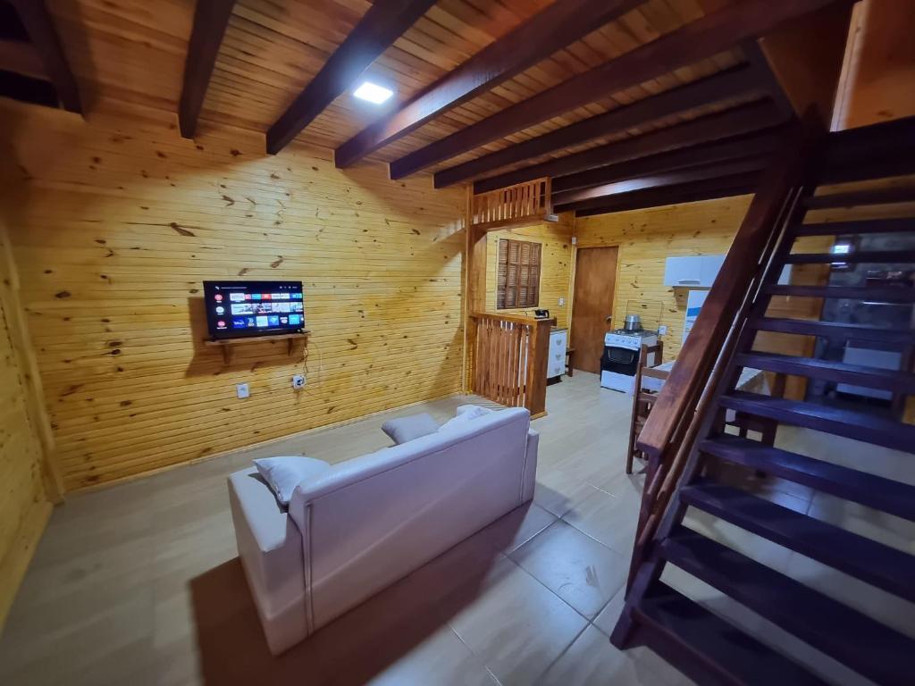 een woonkamer met een bank in een houten kamer bij Cabañas Jardines in Bella Unión