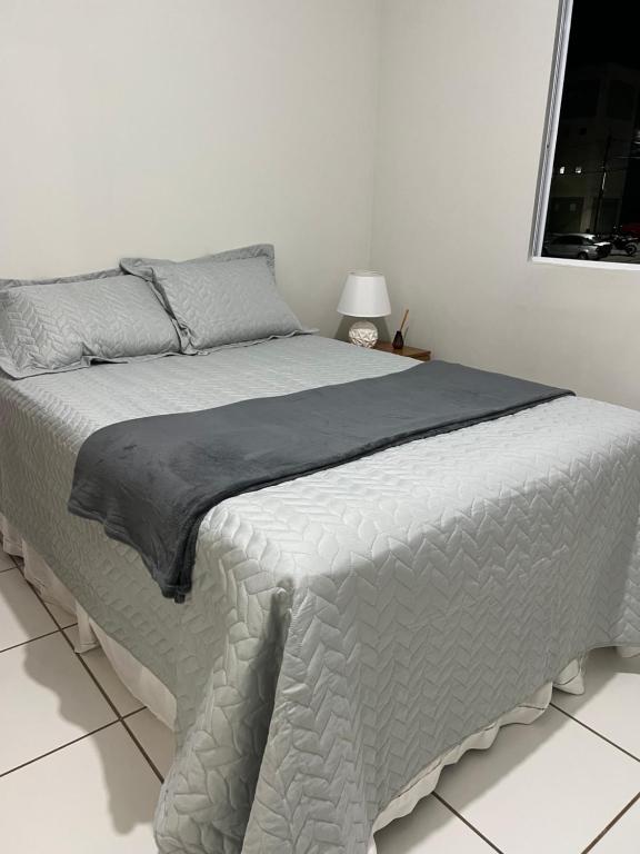 a white bedroom with a bed with a gray blanket at Temporada 101 in Garanhuns