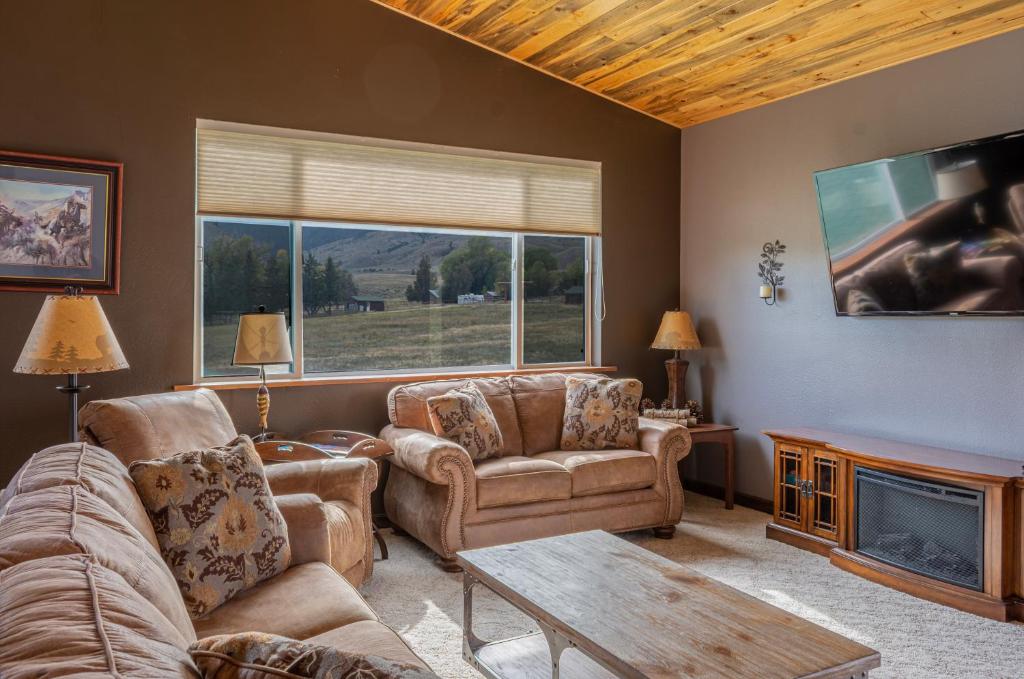 sala de estar con sofá, sillas y chimenea en Large home less than 5 miles to Yellowstone North Entrance, Sleeps up to 8 en Gardiner