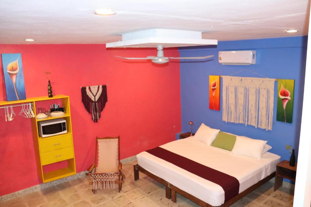 ein Schlafzimmer mit einem Bett und einer roten Wand in der Unterkunft Céntrico y Encantador Apartamento Angielin in Valladolid