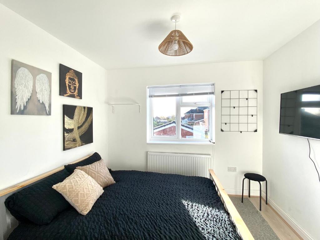 a bedroom with a bed and a window and a television at Chic Retreat: 2-Bed 1 Ensuite Oasis in Birmingham
