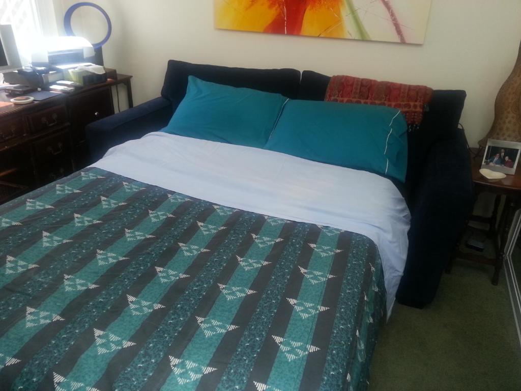 um quarto com uma cama com uma colcha azul e verde em Centrally located; Walk anywhere! em São Francisco