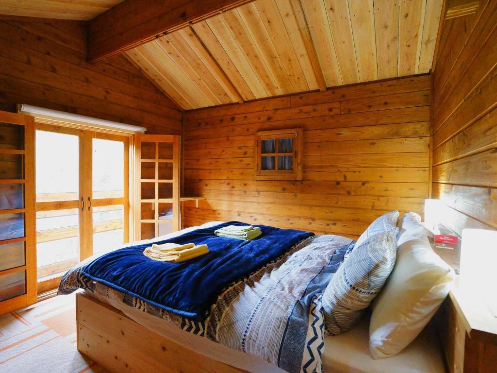 a bedroom with a bed in a log cabin at Alpages - Vacation STAY 11099 in Myoko
