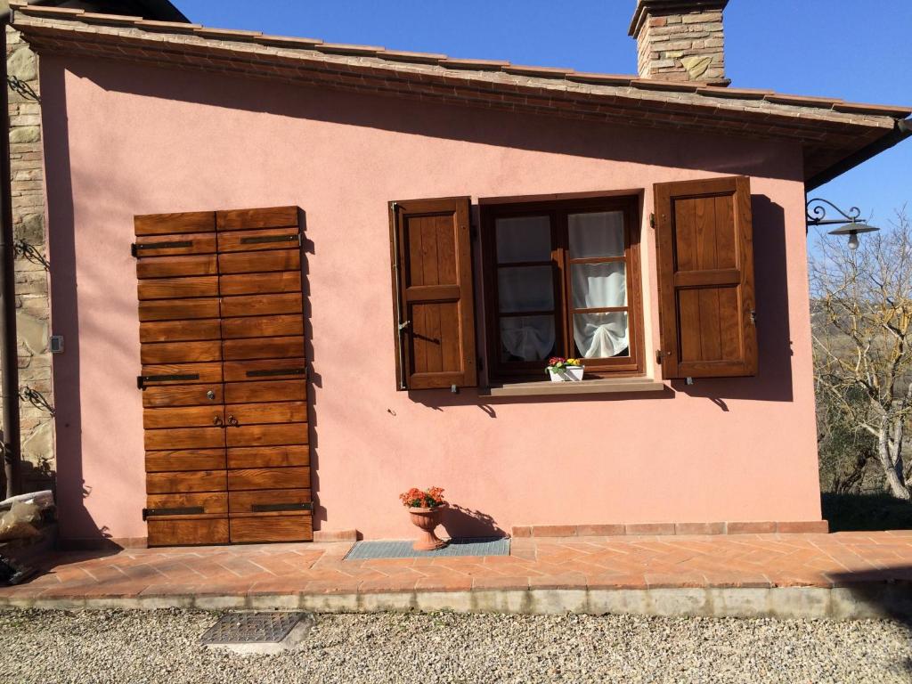 a dog sitting in front of a house with a window at Casina Rosa in Certaldo
