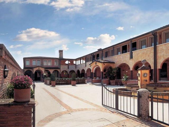 un patio de un edificio con una valla en Hotel Il Chiostro, en Oppeano