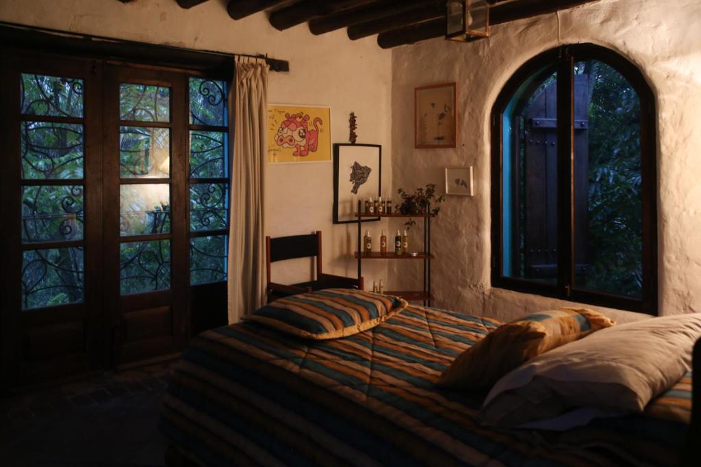 a bedroom with a bed in a room with windows at Espacio Pueblo. Galería rural in Amaguaña