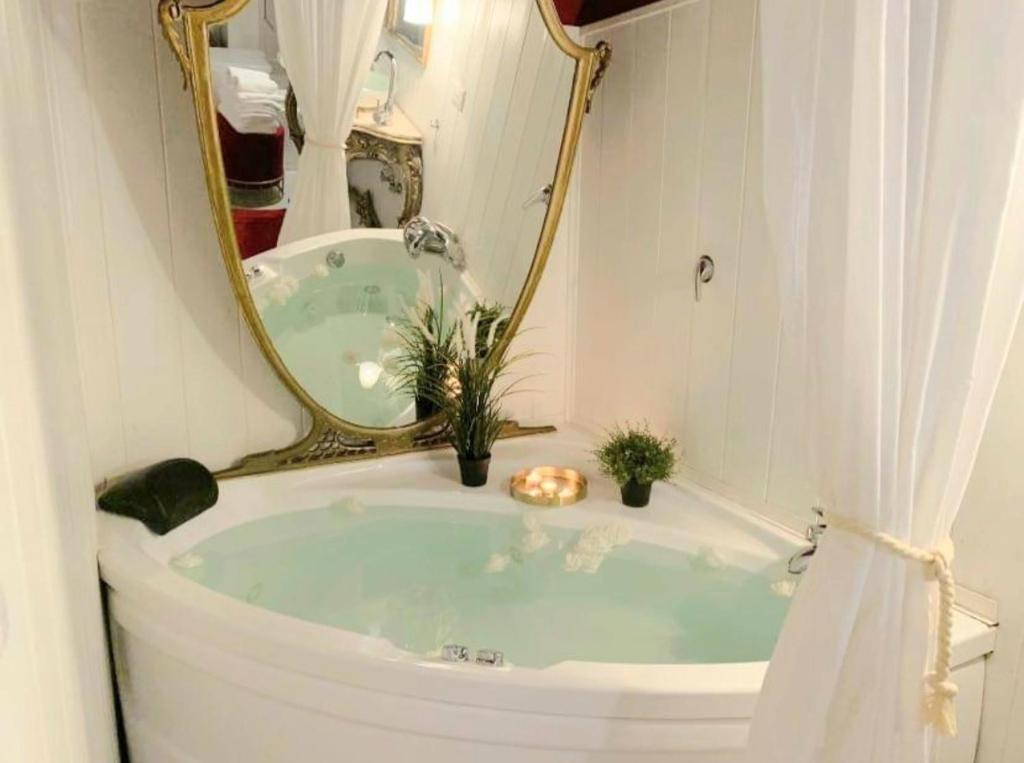 a bathroom with a tub with a mirror at B&b Morosoli Palace in Catania