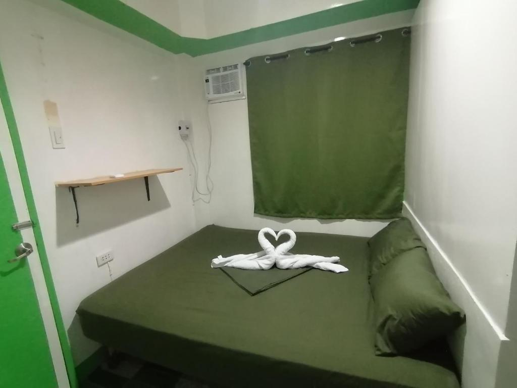 a room with a bed with a white ribbon on it at Ustaris Homestay in Itaytay