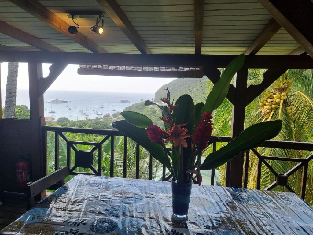 a vase with flowers on a table on a balcony at Lodge grenadine in Deshaies