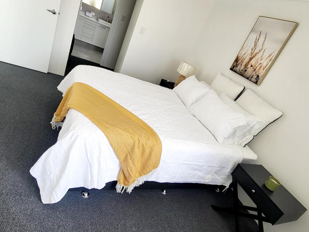 a bedroom with a large bed with white sheets and pillows at Comfort oasis family getaway in Henley Brook
