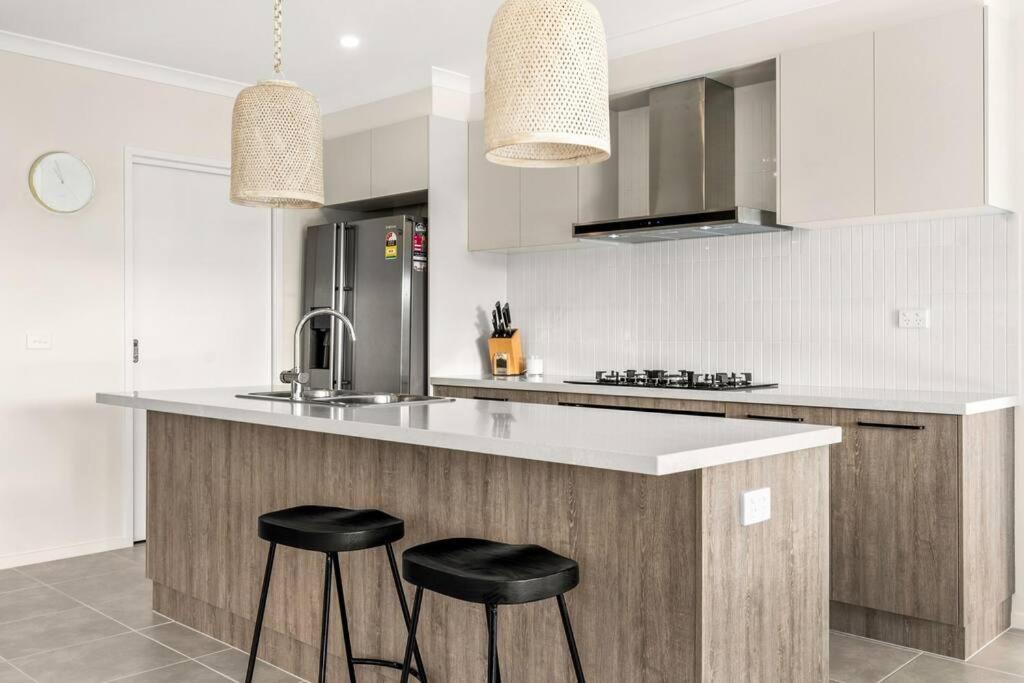 een keuken met twee krukken aan een aanrecht bij Elsa Remo - Stylish Ultra modern in San Remo