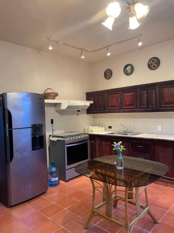 a kitchen with a stainless steel refrigerator and a table at Mex’ s House in Pisté