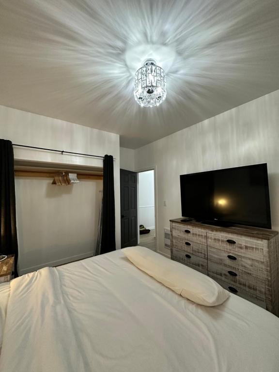 een slaapkamer met een bed en een flatscreen-tv bij Charming 2BD/1BA Home with Modern Amenities in Duncan