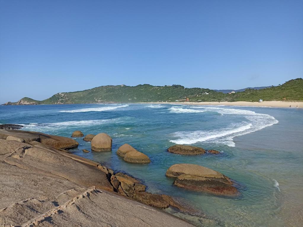 a group of rocks in the water on a beach at Dunas Tiny House Casa 2 in Florianópolis