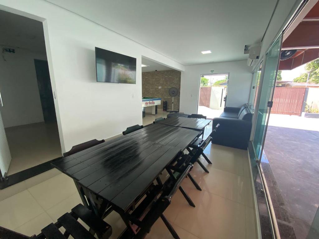 a long wooden table and chairs in a room at Conexão 021 in Boa Vista