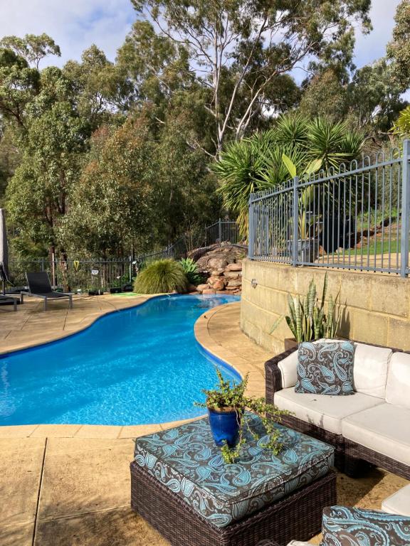 a swimming pool with a couch and a table next to it at Robinson Retreat in Darlington